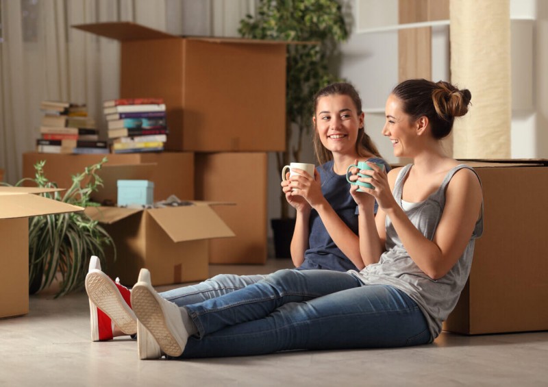 Two women sat down with boxes full of items around them