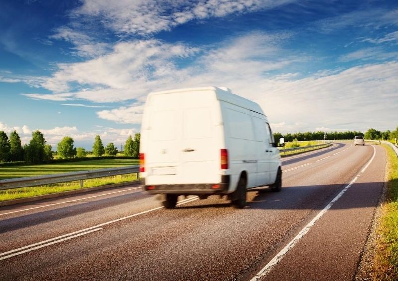 Van driving on a road during the day