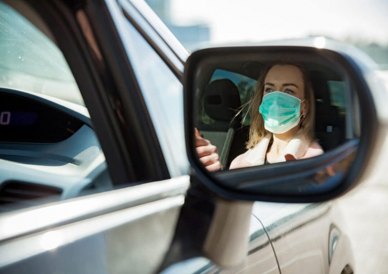 Woman driving while wearing a face mask