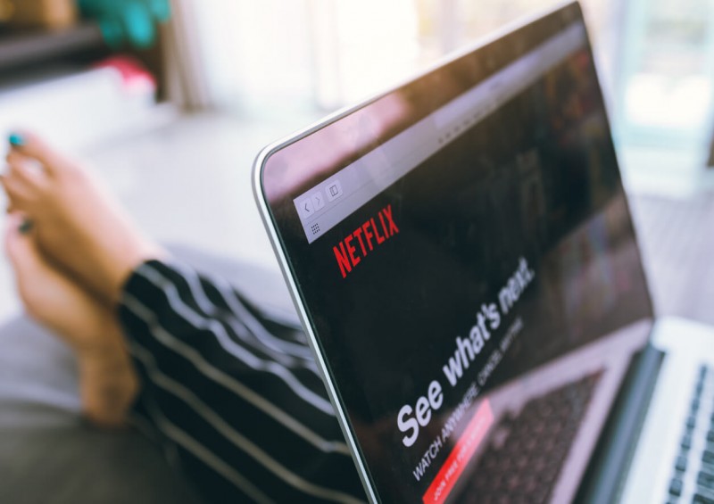 Woman holding her laptop with Netflix on the screen