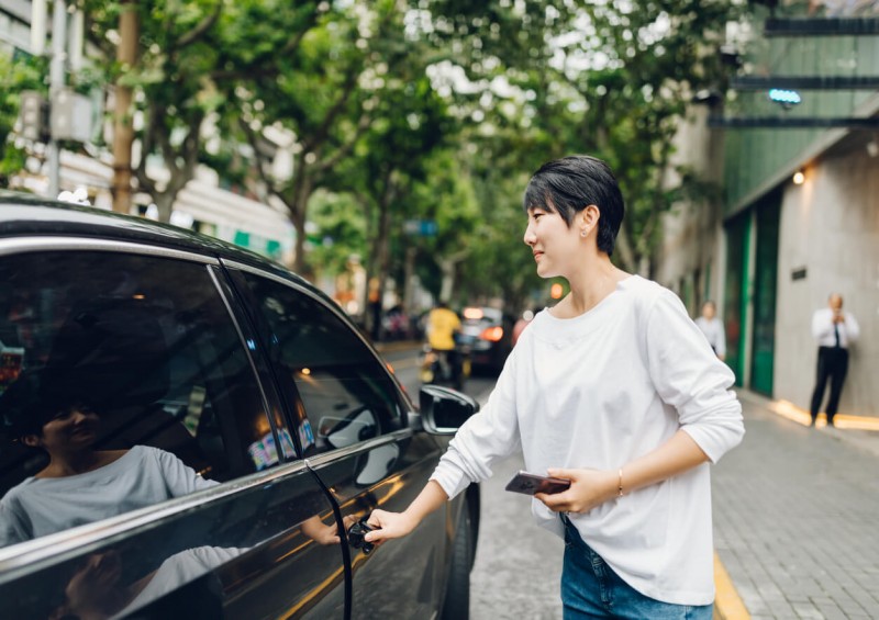 Woman opening an Uber taxi door