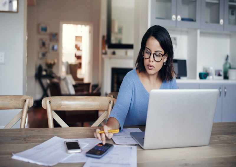 woman sat at table calculating finances