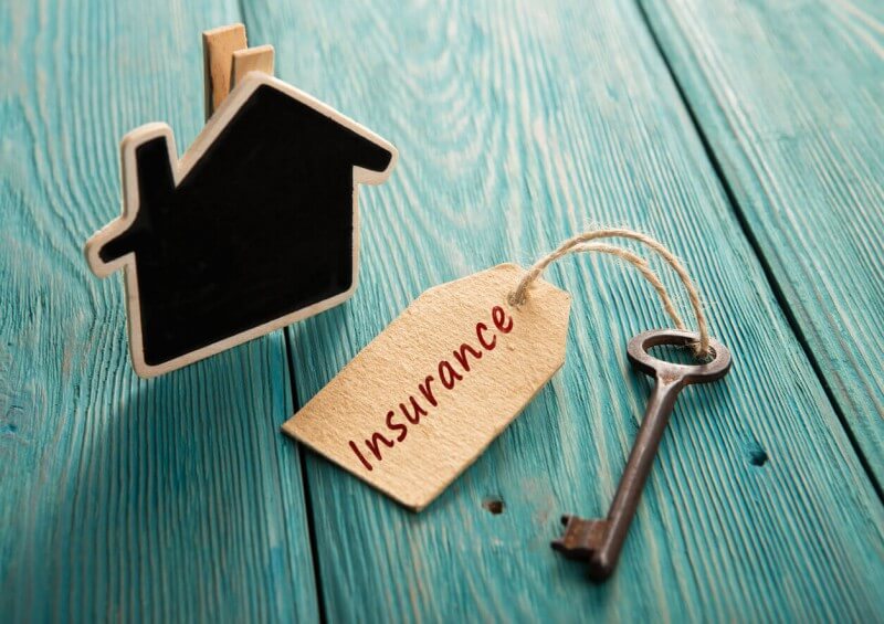 Wooden house with key and insurance tag