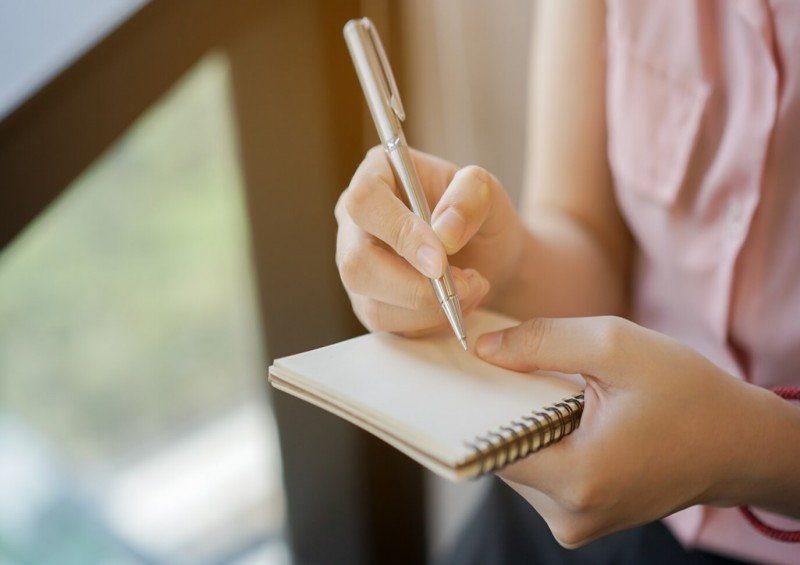 Writing a checklist on a notepad