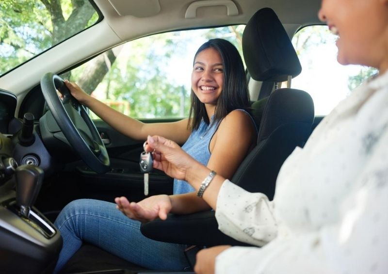 Young driver being given keys to first car