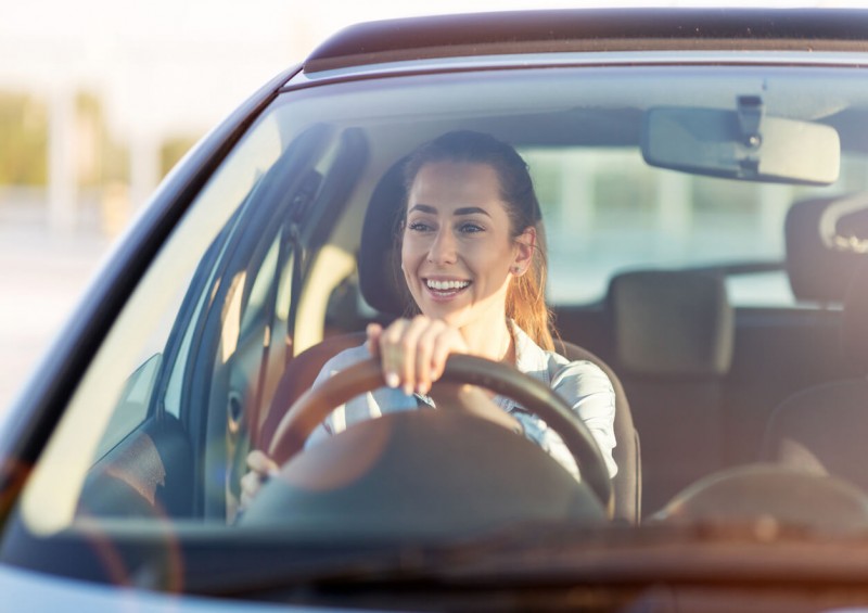 Young woman driving car with black box insurance