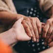 A close up of two people holding hands