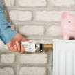 A man turning up the dial on a radiator