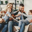 A mother and father laughing with their two children