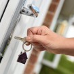 A person opening their front door with a spare key