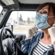 A woman taking off her mask while in the car