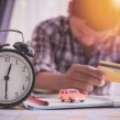 Clock and man stressed about finances