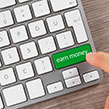 Computer keyboard with green button saying earn money