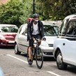 Cyclist driving through cars with mask on