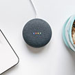 Google Home Mini next to laptop