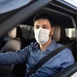 Man driving a car with a face mask on