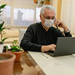 Man wearing coronavirus mask checking will online