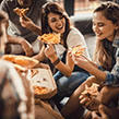 Millennials eating pizza takeaway together