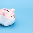 Money piggy bank with covid mask on