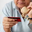 Older man giving bank details to scammer over phone