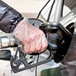 Person putting fuel in car with safety glove on