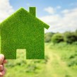 Someone holding a green toy house