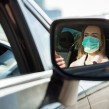 Woman driving while wearing a face mask