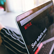 Woman holding her laptop with Netflix on the screen