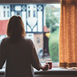 Woman looking out window during Coronavirus quarantine