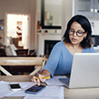 woman sat at table calculating finances