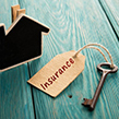 Wooden house with key and insurance tag